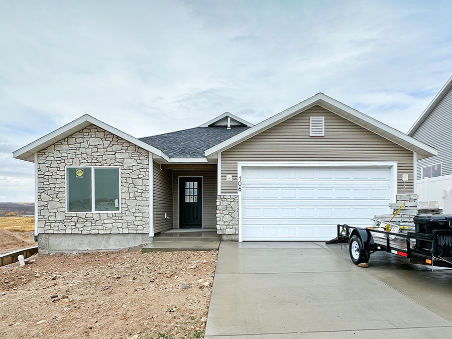 106 Kachina way featuring tan and white siding, black shingles, sleek black hardware and finishes, white speckles countertops, grey and white cabinetry.